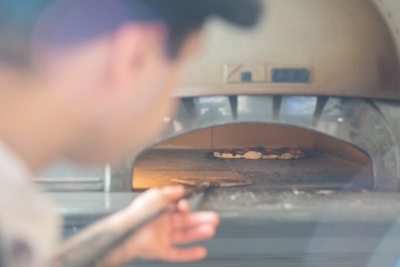 anthonys coal fired pizza chef working at the coal fired oven